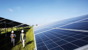 Workers walk past solar panels at the largest solar electricity plant in Thailand in 2014. 