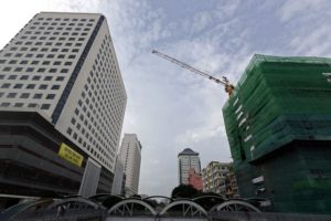 Crane set up at a construction site among tall buildings in downtown Yangon.