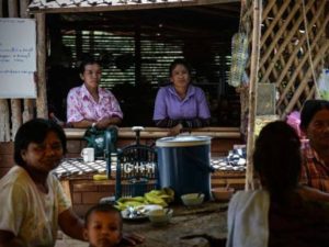 Residents who have adopted renewable energy relaxing at the community center of Pa Deng village